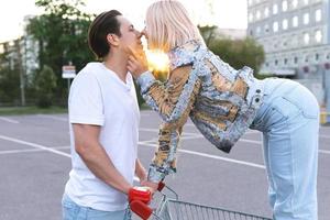 jeune couple avec un caddie sur un parking de supermarché photo