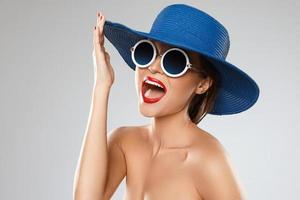 belle femme portant un chapeau bleu et des lunettes de soleil est prête pour les vacances photo