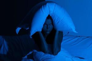 femme dans la chambre avec un oreiller sur la tête photo