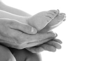 les mains du père tenant les pieds de son bébé photo