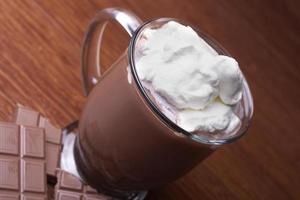 cacao chaud dans une tasse en verre avec de la crème essuyée photo