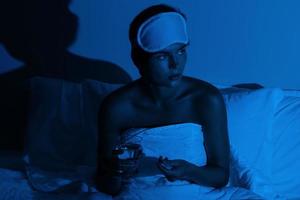 femme dans la chambre avec un verre d'eau et des somnifères photo