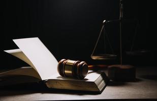 concept de justice et de droit. juge masculin dans une salle d'audience avec le marteau, travaillant avec, clavier d'ordinateur et d'accueil, lunettes, sur table à la lumière du matin photo