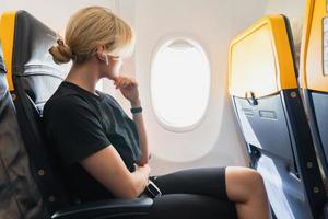 femme écoutant de la musique à l'intérieur d'un avion pendant son vol photo