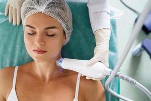 femme pendant le traitement de levage par radiofréquence dans une clinique médico-esthétique photo