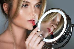 femme avec tube de rouge à lèvres et miroir rond avec led photo