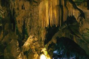 grotte souterraine sombre et naturelle avec des stalactites aux formes étranges. photo