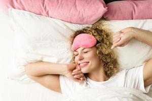 belle femme aux cheveux bouclés se réveillant après un bon sommeil photo