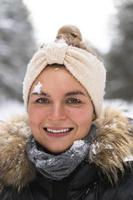 jeune fille joyeuse profitant des chutes de neige pendant la belle journée d'hiver photo