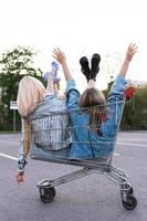 deux jeunes filles heureuses assises dans un caddie photo