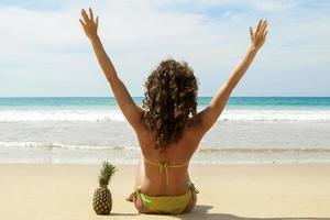 femme avec un fruit d'ananas sur la plage photo