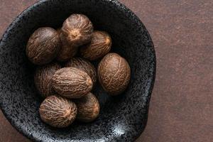 noix de muscade entière dans un bol photo