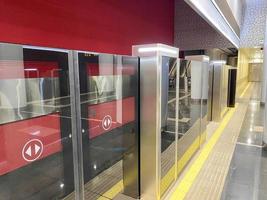 système de plate-forme de porte automatique dans une nouvelle station de métro moderne. système de sécurité du métro de belles portes en verre s'ouvrent de manière synchrone avec les portes de la voiture de train qui arrive photo