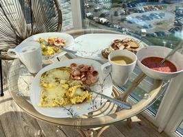 omelette avec des morceaux de pain grillé, du fromage de chèvre et une tasse de café. petit déjeuner délicieux et nutritif. la main masculine prend une assiette, vue de dessus. bannière photo