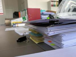 grands dossiers épais avec des papiers et des documents importants sur un bureau de travail avec papeterie et accessoires photo