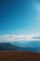 paysages avec ciel bleu et nuages, route à travers les sommets des montagnes et les collines à travers le majestueux photo