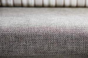 gros plan d'un fragment d'un canapé textile beige dans la chambre. texture de tissu coûteux sur les meubles photo