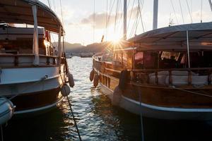 yachts sur la jetée, sur fond d'un beau ciel coucher de soleil avec des rayons de soleil. photo