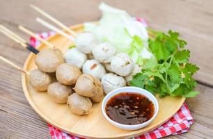 boulettes de viande sur assiette avec sauce épicée, boulette de viande grillée et boule de porc, boulette de viande sur brochettes et chou de légumes frais à la coriandre, cuisine thaïlandaise boulettes de viande de cuisine asiatique - boulettes de porc photo