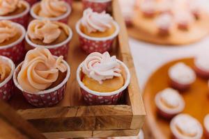 cupcakes gastronomiques avec glaçage au beurre blanc et arrose sur fond de bois photo