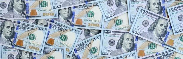 un grand nombre de billets d'un dollar américain d'un nouveau design avec une bande bleue au milieu. vue de dessus photo