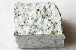 roche de granit blanc rugueux sur marbre blanc photo