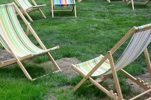 chaises longues sur une pelouse. transats de jardin sur l'herbe verte photo