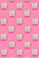 beaucoup de coffrets cadeaux roses se trouvent sur un fond de texture de papier de couleur rose pastel de mode dans un concept minimal. motif tendance abstrait photo