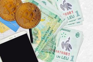 1 billets de leu roumain et bitcoins dorés avec smartphone et cartes de crédit. concept d'investissement en crypto-monnaie. minage ou commerce de crypto photo