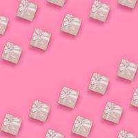 beaucoup de coffrets cadeaux roses se trouvent sur un fond de texture de papier de couleur rose pastel de mode dans un concept minimal. motif tendance abstrait photo