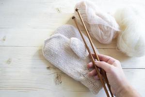 gros plan sur la main d'une femme âgée tenant des aiguilles à tricoter. photo