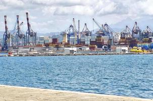 des conteneurs et des grues pour le chargement de machines peuvent être vus dans le paysage industriel de la ville portuaire italienne de la spezia. photo