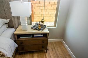 table de chevet de chambre avec lampe de table et plateau décorateur photo