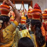 new delhi, inde 03 avril 2022 - femmes avec kalash sur la tête pendant le temple jagannath mangal kalash yatra, les dévots hindous indiens portent des pots en terre contenant de l'eau sacrée avec une noix de coco sur le dessus photo
