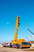 grue de camion lourd avec une flèche. flèche surélevée d'un camion-grue contre le ciel photo