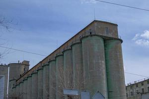 élévateur à grains contre un ciel d'orage. grande structure d'usine contre un ciel bleu, vue à angle bas. photo