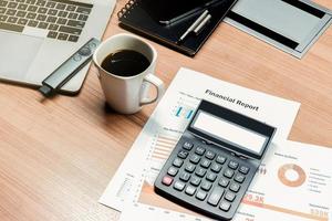 calculatrice vue de dessus, paperasse, tasse à café et ordinateur portable sur table dans la salle de réunion photo