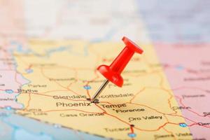 aiguille de bureau rouge sur une carte des états-unis, de l'arizona et de la capitale phénix. gros plan de l'orizona avec tack rouge photo