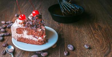 gâteau au chocolat savoureux fait maison avec des baies et un boulanger ou un chocolatier préparant du chocolat en fouettant le chocolat fondu avec un fouet dégoulinant sur la casserole ci-dessous photo