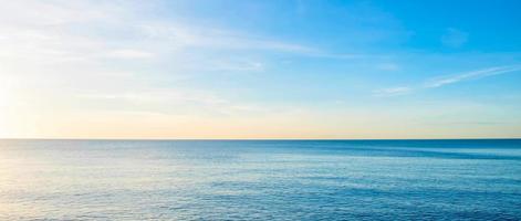 la vue sur la mer le matin avec les rayons dorés du soleil qui brillent sur la mer en été photo