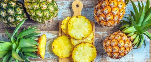 vue de dessus d'ananas tranché et demi et de fruits d'ananas frais placés sur un vieux fond en bois photo