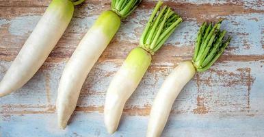 vue de dessus de légume frais de radis blanc placé sur un vieux fond en bois. radis brut photo