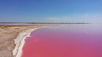 vue aérienne de sel blanc sur les rives de l'île en île rose et ciel bleu. lac lemuria, ukraine. le lac devient naturellement rose à cause des sels et des petits crustacés artemia dans l'eau photo