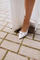 mariée avec des chaussures blanches aux pieds. concept de mode de mariage festif. photo de haute qualité