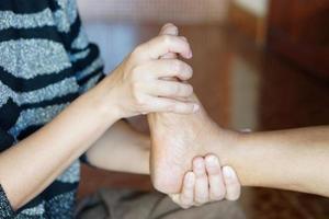 mains de femme gros plan masser le pied du patient. concept, soins de santé, premiers soins pour les crampes aux jambes. problèmes de santé. photo