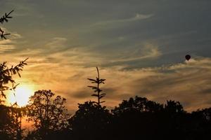 coucher de soleil en été avec une montgolfière dans le ciel photo