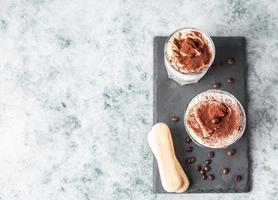 tiramisu de dessert italien traditionnel, fond de pierre. portion aromatisée au café dessert composé de savoiardi et de mascarpone décoré de cacao. photo