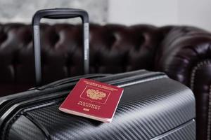 passeport russe sur une valise de voyage noire, mise au point sélective. émigration des russes du pays, problèmes de visas, réfugiés photo