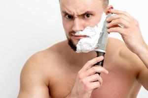 homme se rasant la barbe avec un couteau photo