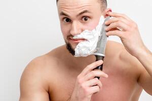 homme se rasant la barbe avec un couteau photo